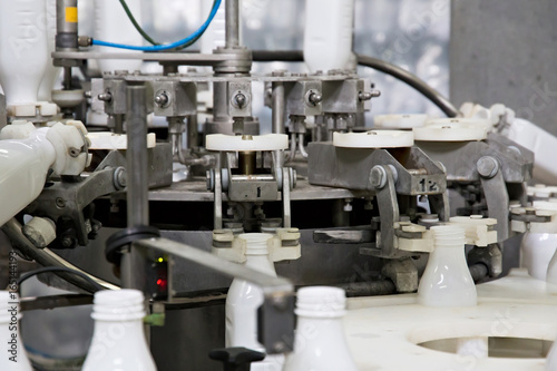 Industrial dairy production. Part of automatic conveyor with bottles for milk.