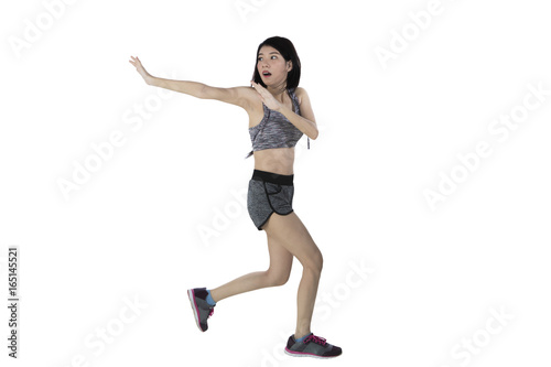 Fototapeta Naklejka Na Ścianę i Meble -  Scared slim woman running from something