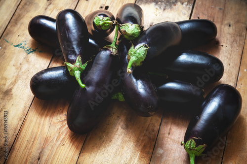 Several ripe eggplant lay on boards