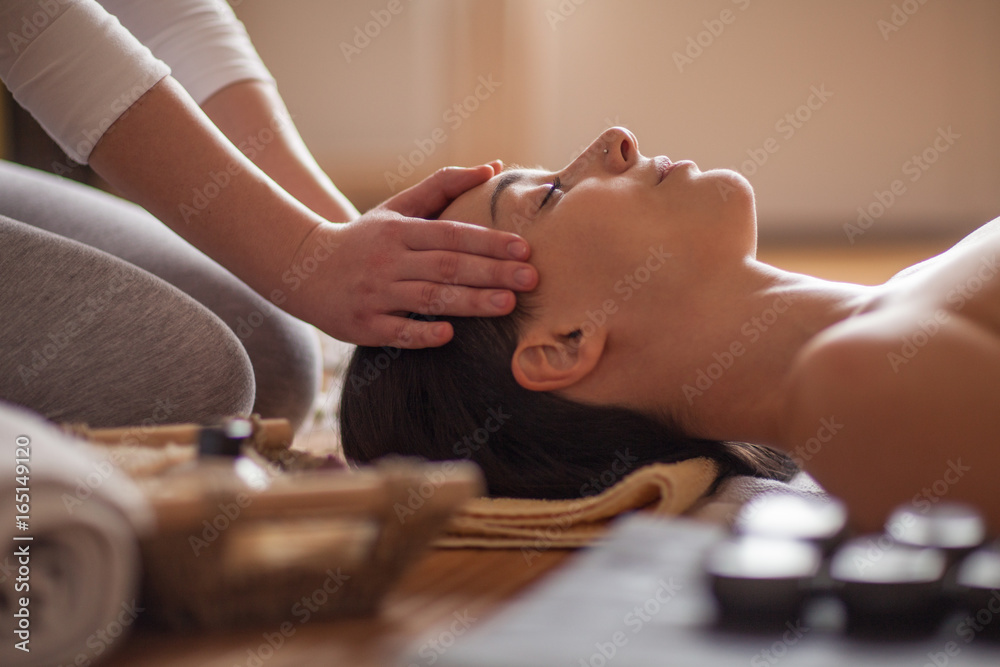 © Mosuno/Stocksy - Woman receiving a head massage at spa