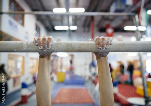 Child practices on the parallel bars in a gymnastics gym photo