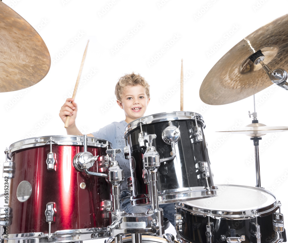 Obraz premium young caucasian boy plays drums in studio against white background