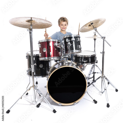 young caucasian boy plays drums in studio against white background Fototapet