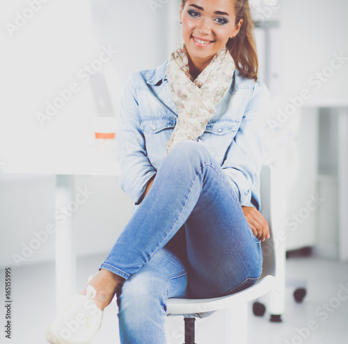 Attractive young woman standing near table in office