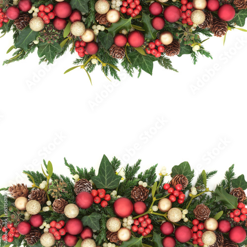 Christmas background border with gold and red bauble decorations, holly, ivy, mistletoe, fir and pine cones on white.