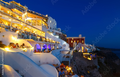 Night restaurant with tourists from Fira Santorini, the famous European resort, Greece photo