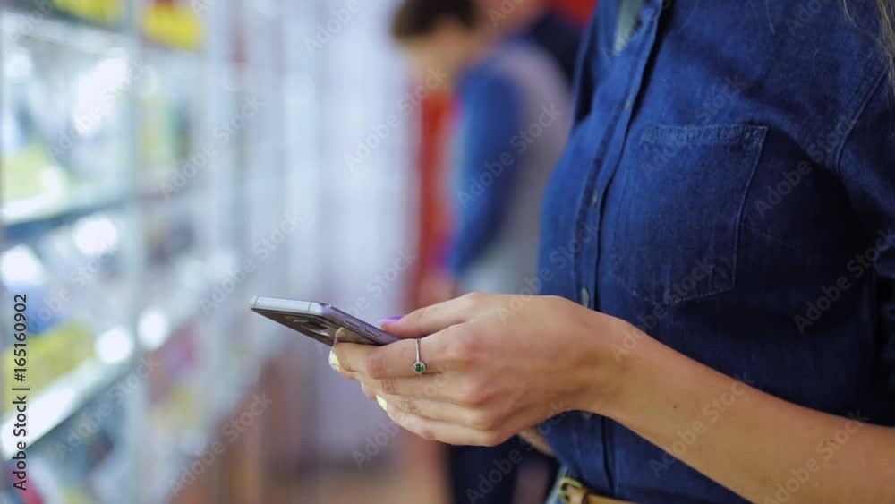 young girl with phone in hands in electronics store, closeup young girl with phone in hands in electronics store, closeup
