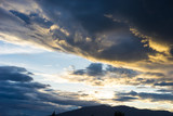 Dramatic sky with dark clouds above the mountain at sunset.
