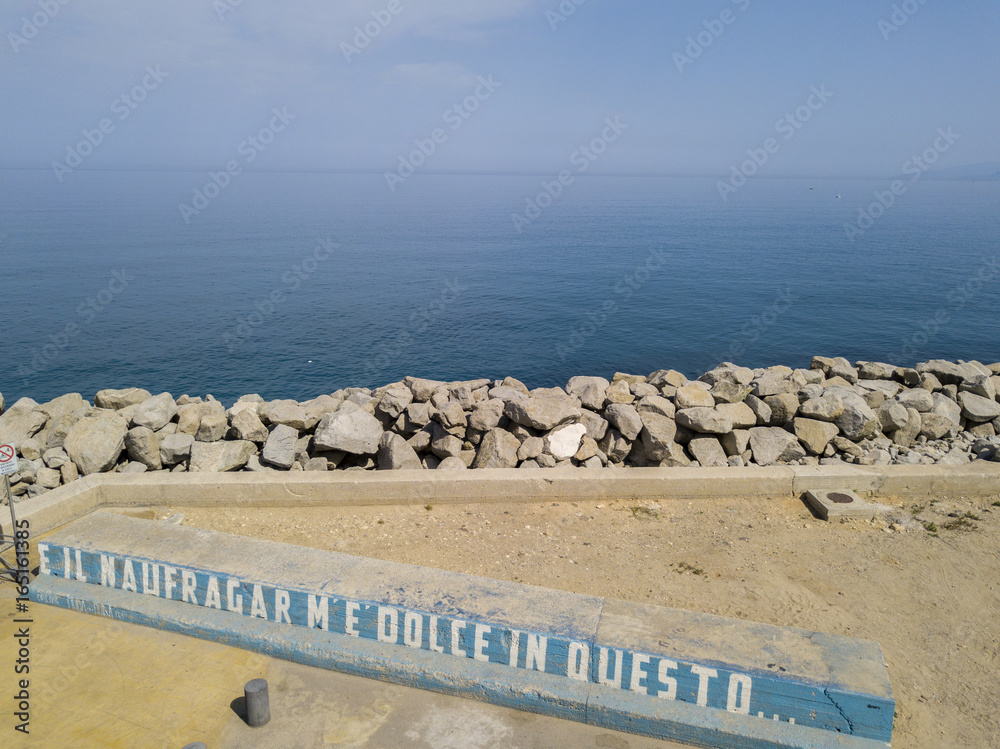 Molo e scritta: e il naufragar m'è dolce in questo mare, vista aerea