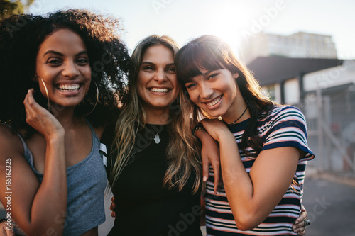 Three young women having fun on city street