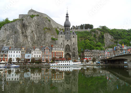 Reflections of gorgeous church and architecture of Dinant on the Meuse river, Wallonia region, Belgium