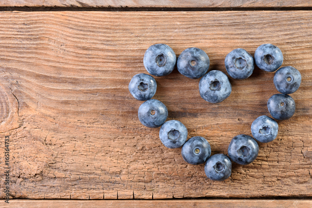 Heart from fresh blueberries on an old wooden background top view with copy space. Fresh blueberries. Blueberry. Heart from fresh blueberries on an old wooden background top view with copy space. Fresh blueberries. Blueberry.