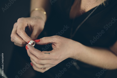 Closeup of a woman_��s hands holding a silver ring photo