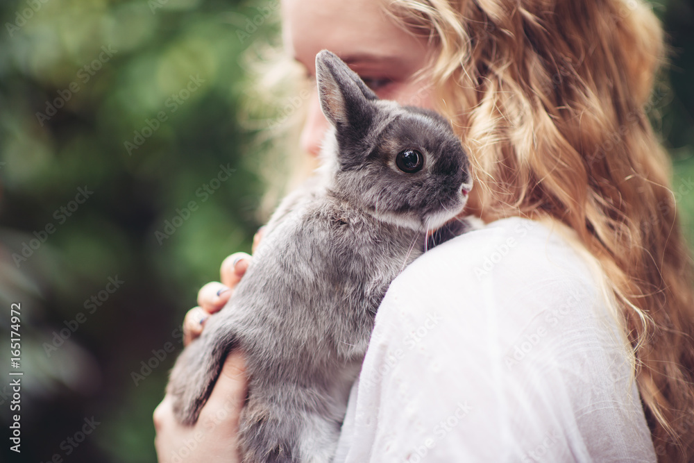 Teenage girl with a small grey rabbit Teenage girl with a small grey rabbit