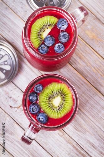 Berry kiwi smoothie in the jars. View from above, top studio shot