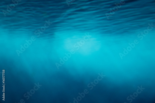 Underwater light ray beams background in blue tone.