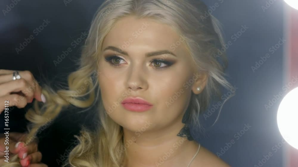 girl looks in the mirror at the Barber's and hairdresser is doing her hair girl looks in the mirror at the Barber's and hairdresser is doing her hair