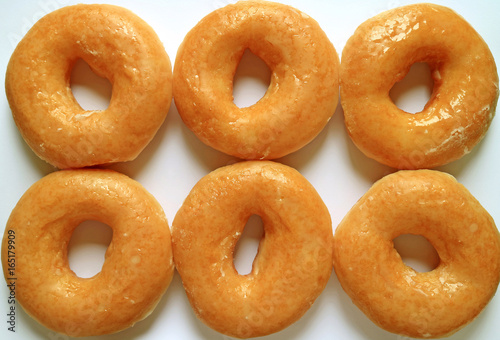 Top view of six sugar-glazed doughnuts, for background and banner © jobi_pro