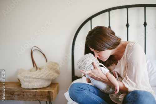 Mother cuddling newborn son photo