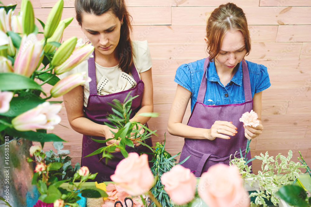 Girl florists working in the Studio over the bouquet Girl florists working in the Studio over the bouquet