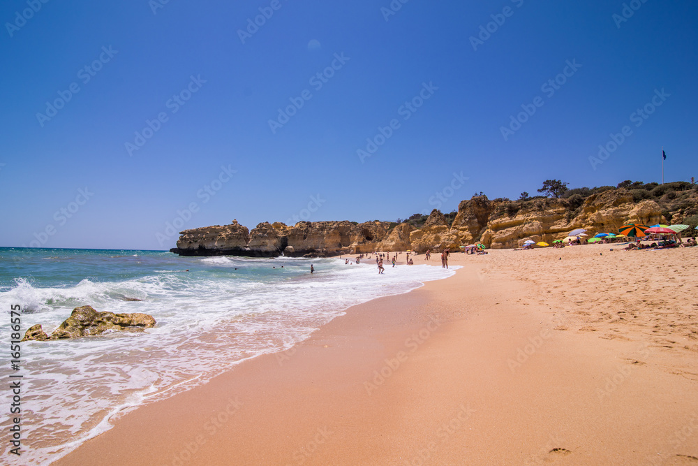 view of beautiful sandy beach on ocean breeze with cave in summer sunny day