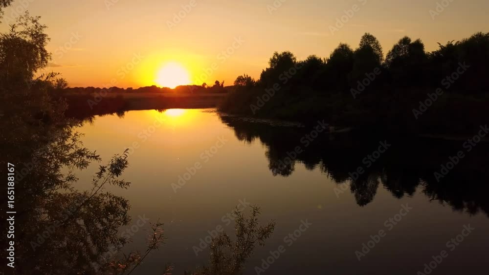 Flying over the trees and river at dawn - aerial videotaping
