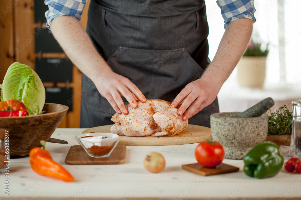male preparing chicken for cooking