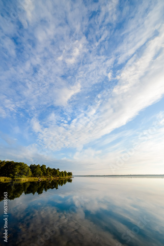 Trees and clouds reflecting in a like