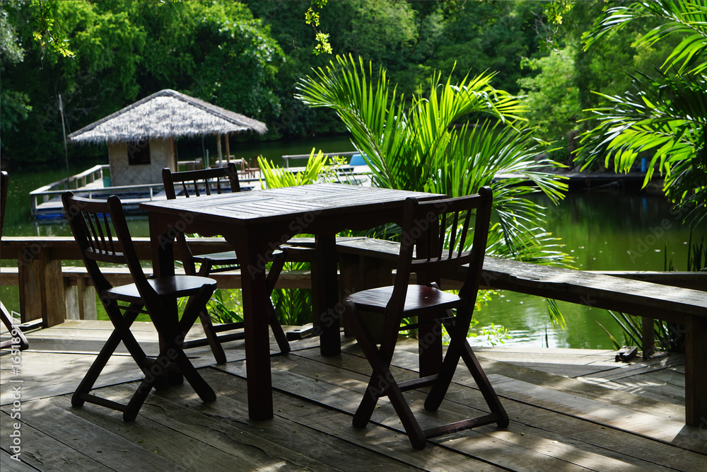 open tropical restaurant table and chairs near natural water