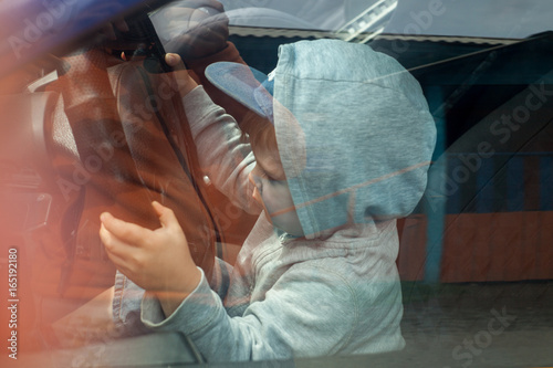 boy sitting in the car as the driver holds the steering wheel car