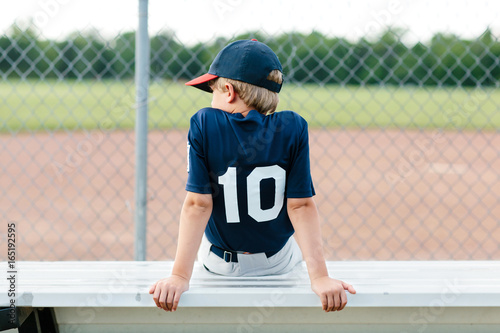 Young baseball player sitting on the bench