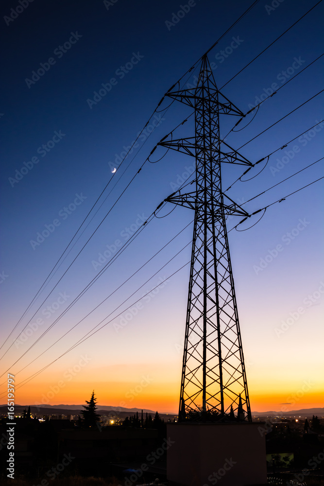Electricity tower close to an urban area against a clear sky