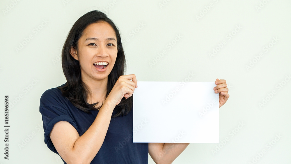 Casual Asian woman holding white sign with copy space Casual Asian woman holding white sign with copy space
