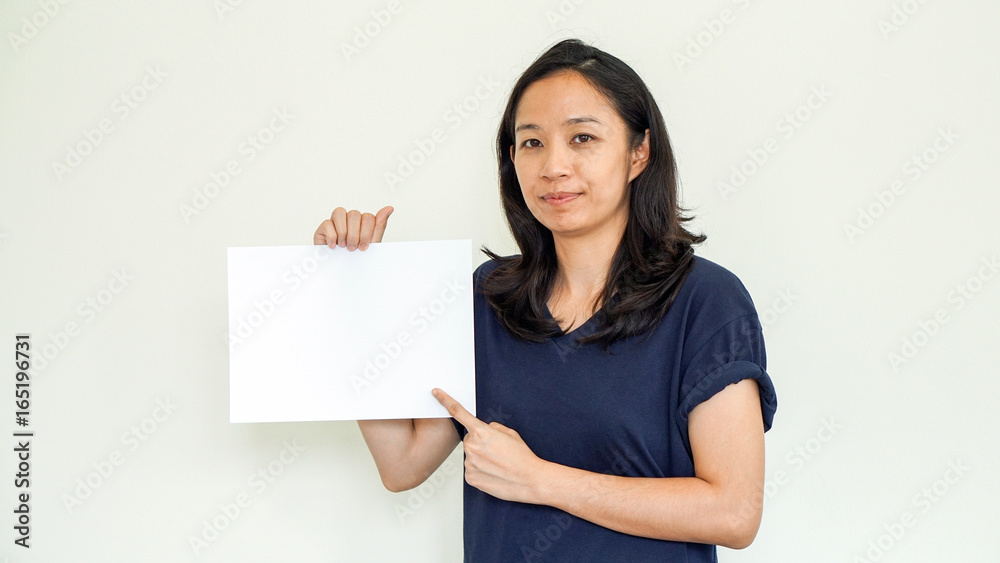 Casual Asian woman holding white sign with copy space Casual Asian woman holding white sign with copy space