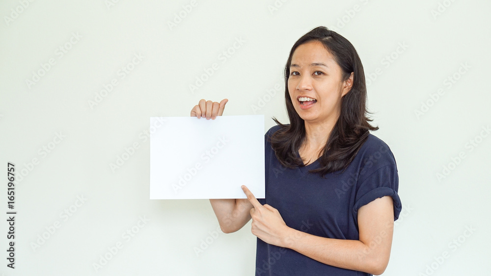 Casual Asian woman holding white sign with copy space Casual Asian woman holding white sign with copy space