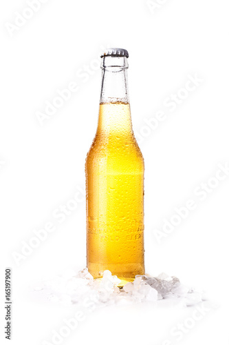 Front view of a closed bottle of blonde beer with lemon inside and white background