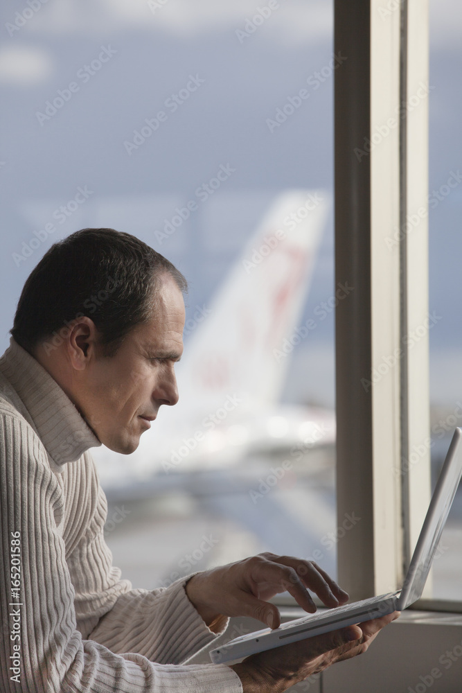 homme en hiver à l'aéroport avec un ordinateur portable homme en hiver à l'aéroport avec un ordinateur portable