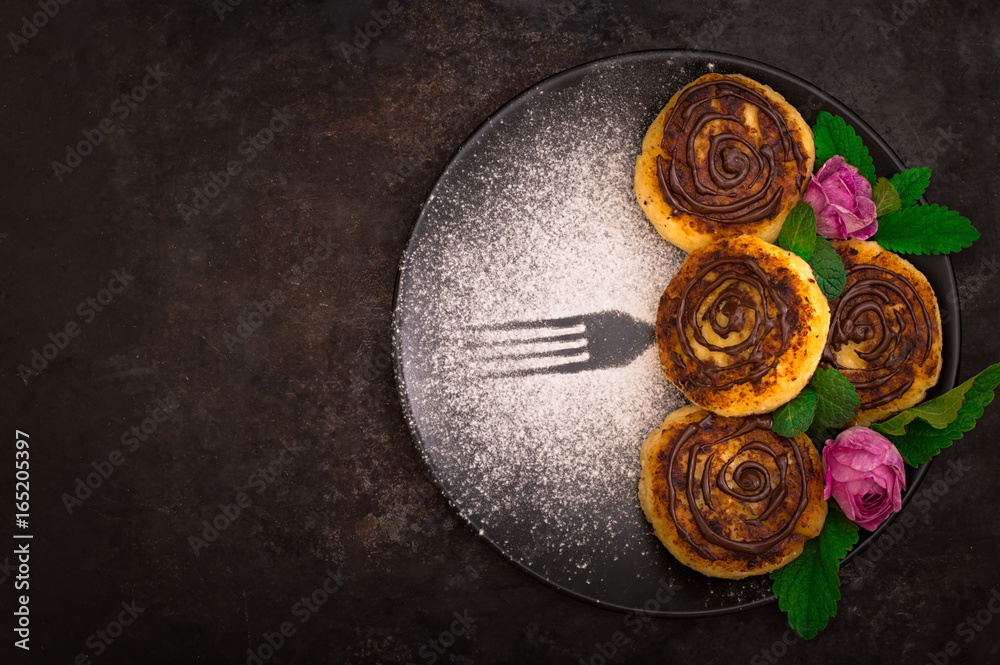 Cheese pancake with chocolate. Old black background. Close-up. Top view Cheese pancake with chocolate. Old black background. Close-up. Top view