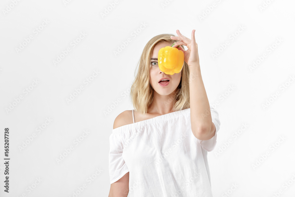 Beautiful blond woman in white blouse holding yellow bell pepper. Health and diet Beautiful blond woman in white blouse holding yellow bell pepper. Health and diet