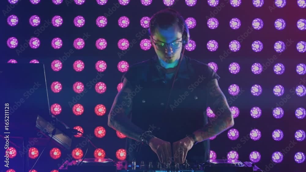 Experienced DJ during his work at a night club. Experienced DJ during his work at a night club.