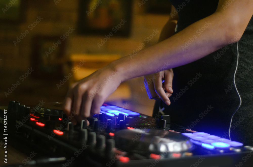 Hands disc jockey at the turntable. DJ plays on the best, famous CD players at nightclub during party. EDM, party concept.