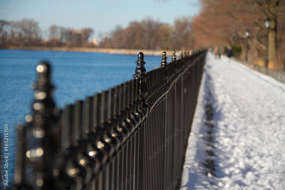 Naklejka premium Black fence near lake with blurred background