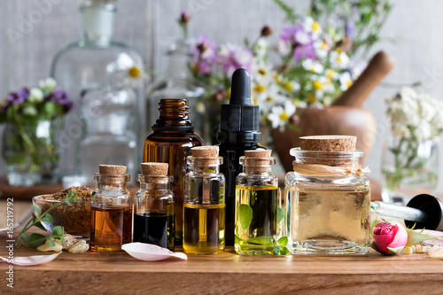 Selection of essential oils with herbs and flowers photo