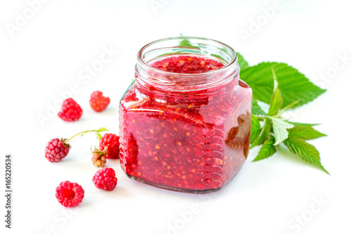 Homemade homemade jam. Glass jar with raspberry jam on a white background. Preserved berry.