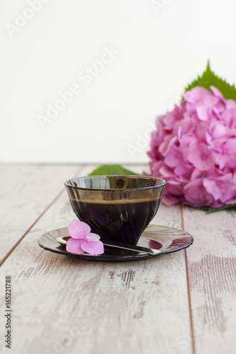 Black cup of coffee with Pink Hidrangea photo