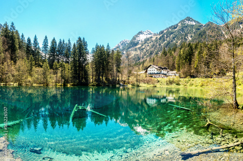 Majestic mountain lake in the Alps. Traditional house at waterside.