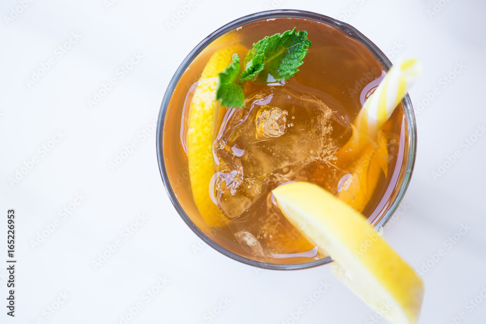 Top Down View of Iced Lemon Tea Garnished with Mint and Yellow Straw on the White Wooden Table Top Down View of Iced Lemon Tea Garnished with Mint and Yellow Straw on the White Wooden Table