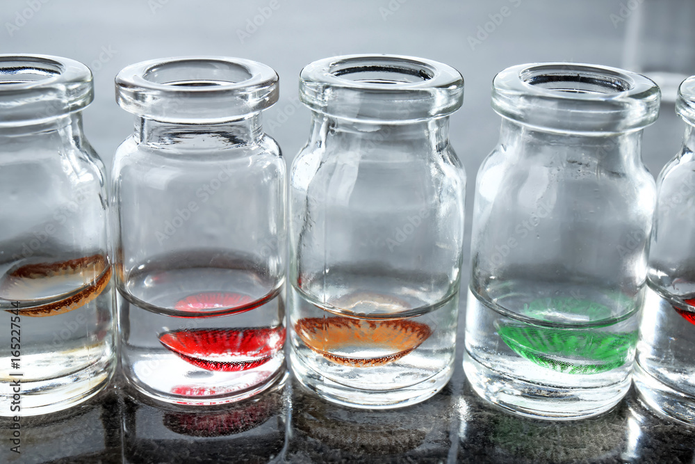 Bottles with contact lenses on gray table Bottles with contact lenses on gray table