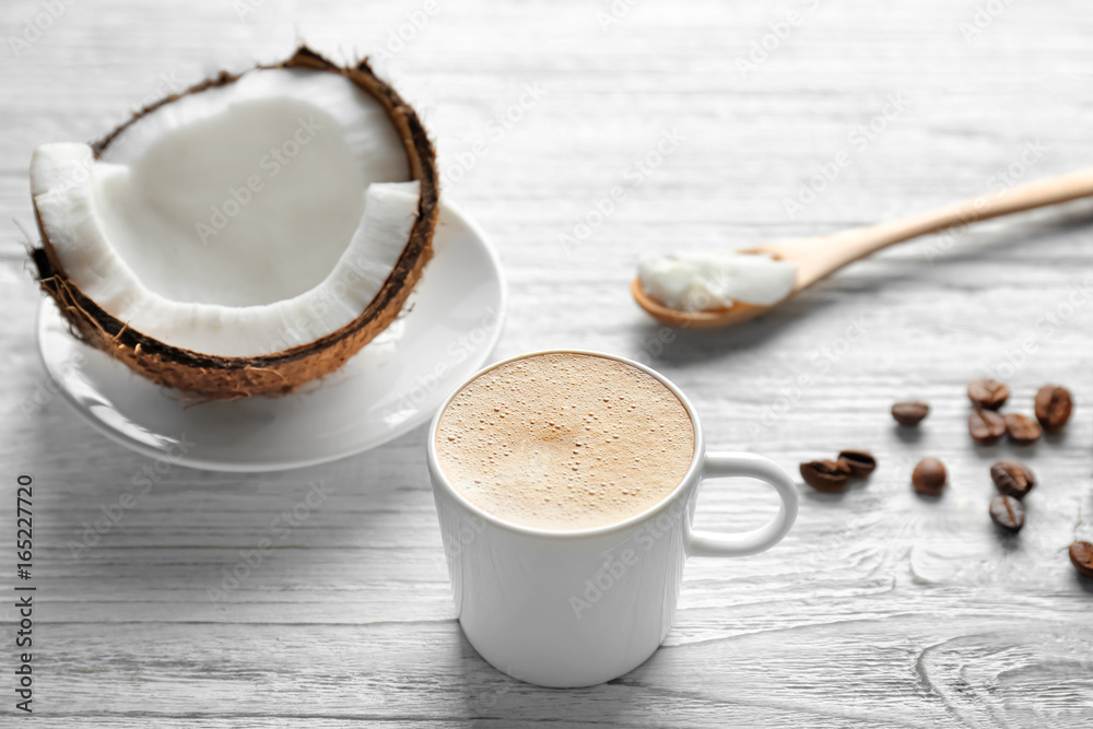 Cup of tasty coconut coffee and nut on wooden table Cup of tasty coconut coffee and nut on wooden table
