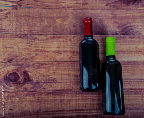 Top view of two wine bottles on a rustic wood table with copy space.